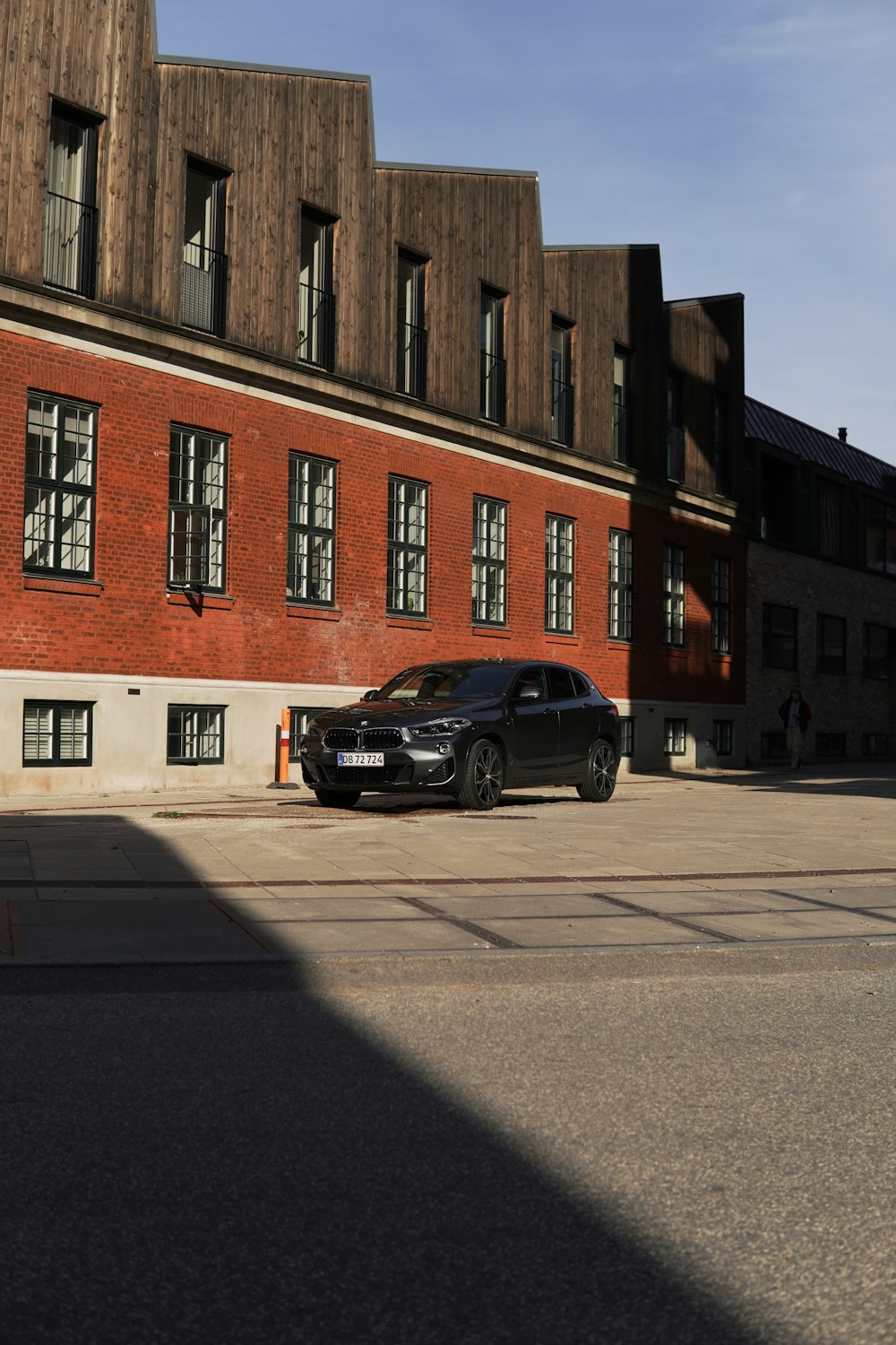 a black car parked in front of a red brick building