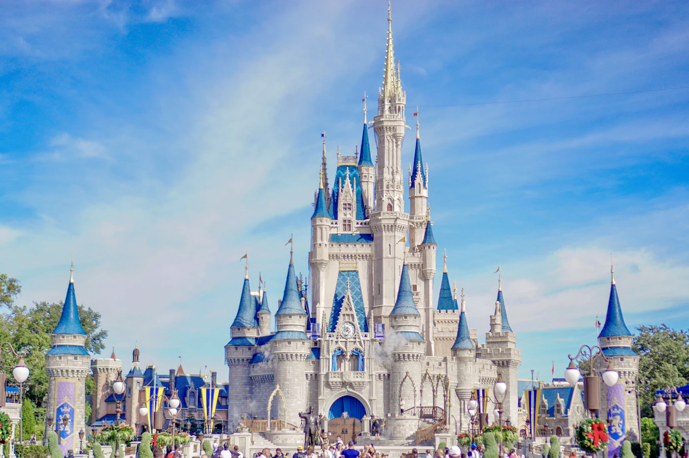 Fairytale Disney castle rising above the park under a blue sky