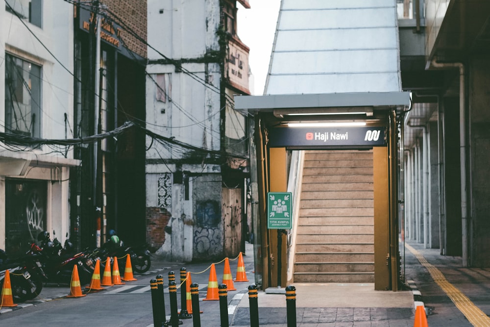 a city street with orange traffic cones and a bus stop