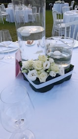 Elegant wedding banquet table set outdoors with floral decorations.