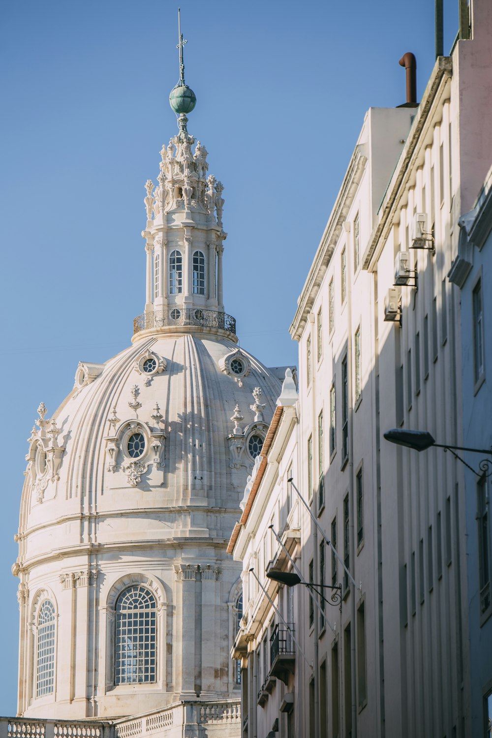 a tall white building with a clock on the top of it