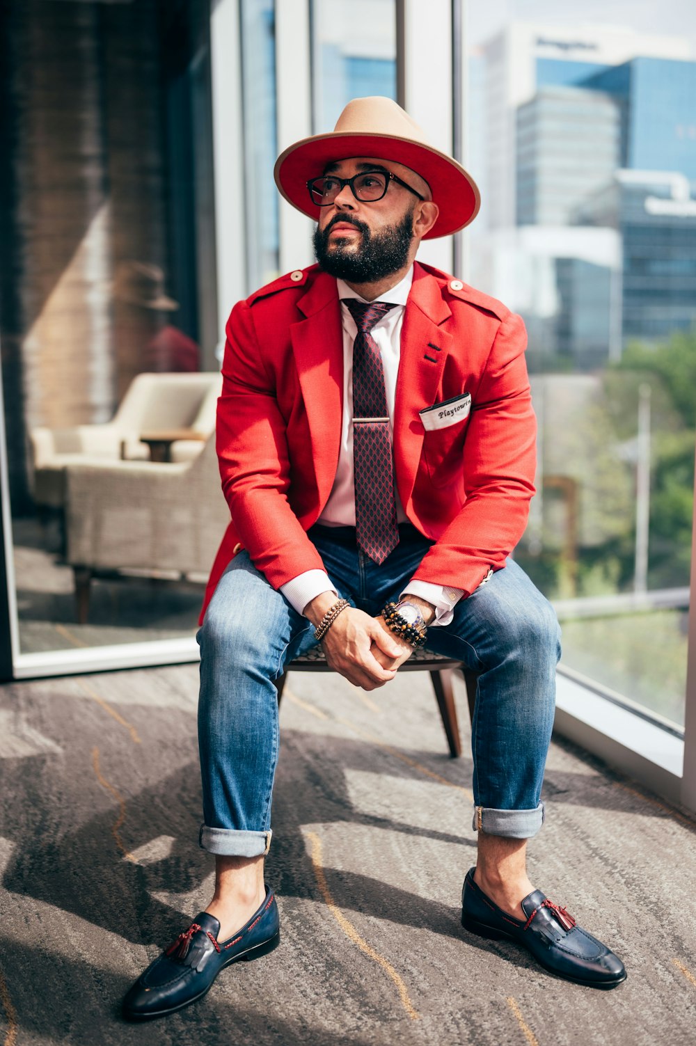 a man in a red suit and hat sitting on a chair