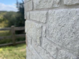 Close-up of a rock wall installation in a residential garden, showcasing natural textures.