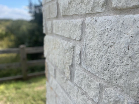 Close-up of a rock wall installation in a residential garden, showcasing natural textures.