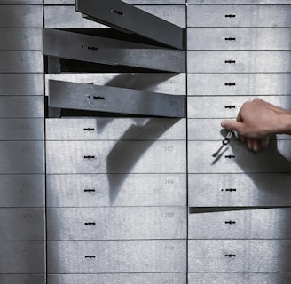 a hand is holding a bunch of keys in front of a metal locker