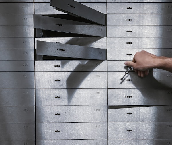 a hand is holding a bunch of keys in front of a metal locker