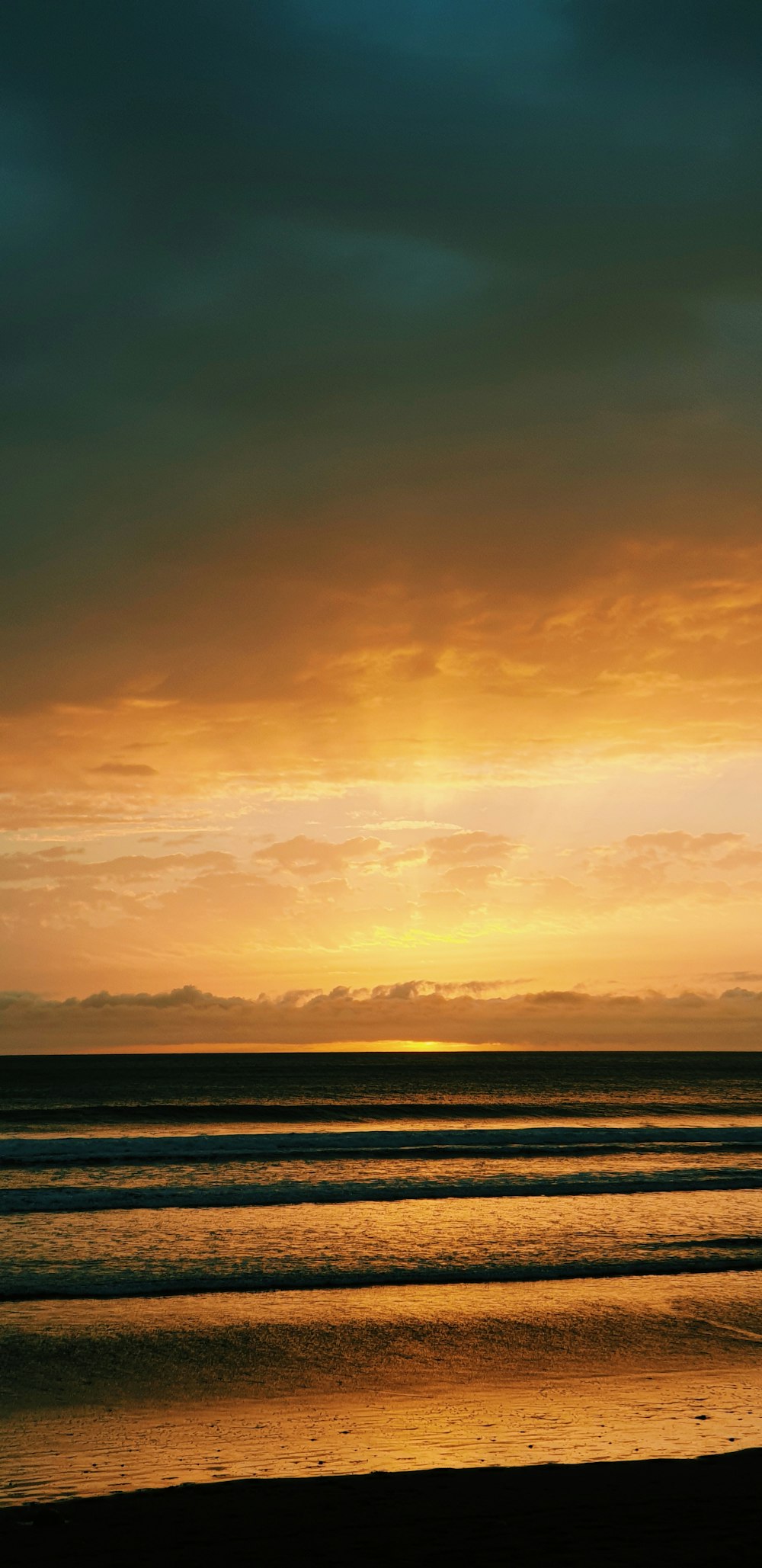 a person walking on the beach with a surfboard