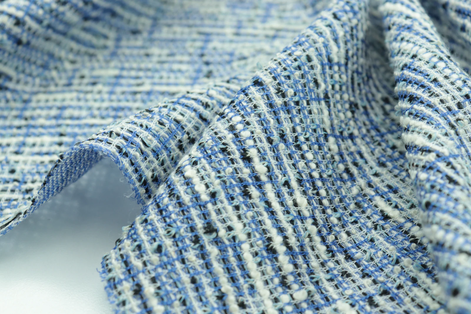 A macro photograph of tweed, the weave and flecks visible.
