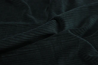A rich, textured knitted fabric in deep black with golden threads catching the light.