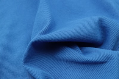 Close-up of moisture-wicking fabric texture on a vibrant blue ActiveFitLab workout top.