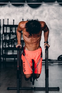 a shirtless man doing a pull up on a bar