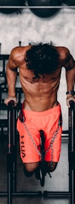 a shirtless man doing a pull up on a bar