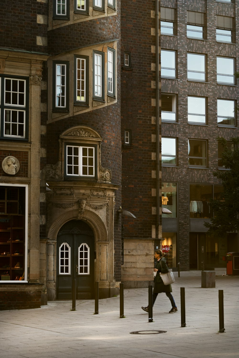 a man walking down a street next to tall buildings