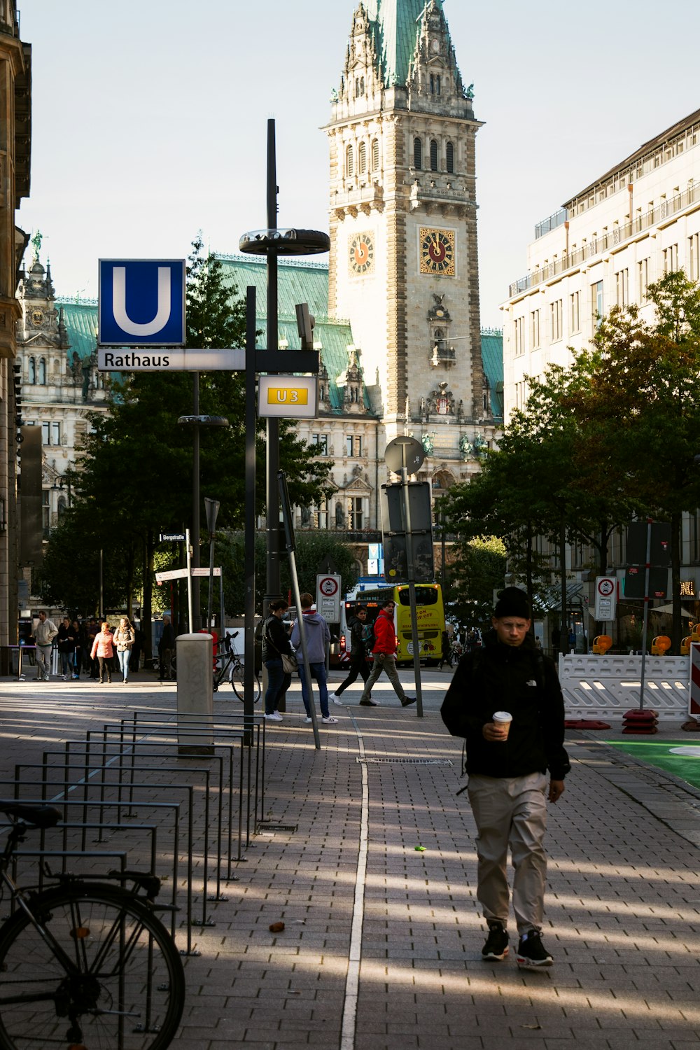 a man walking down a street next to a tall building