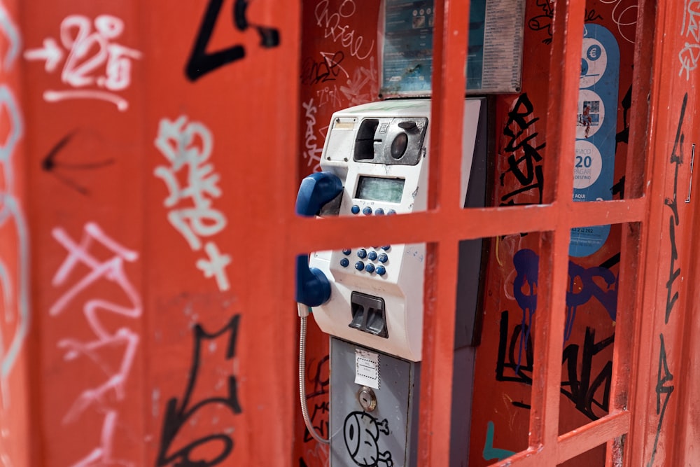 a red phone booth with graffiti all over it