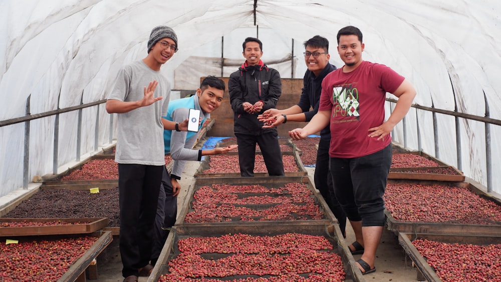 a group of men standing in a greenhouse