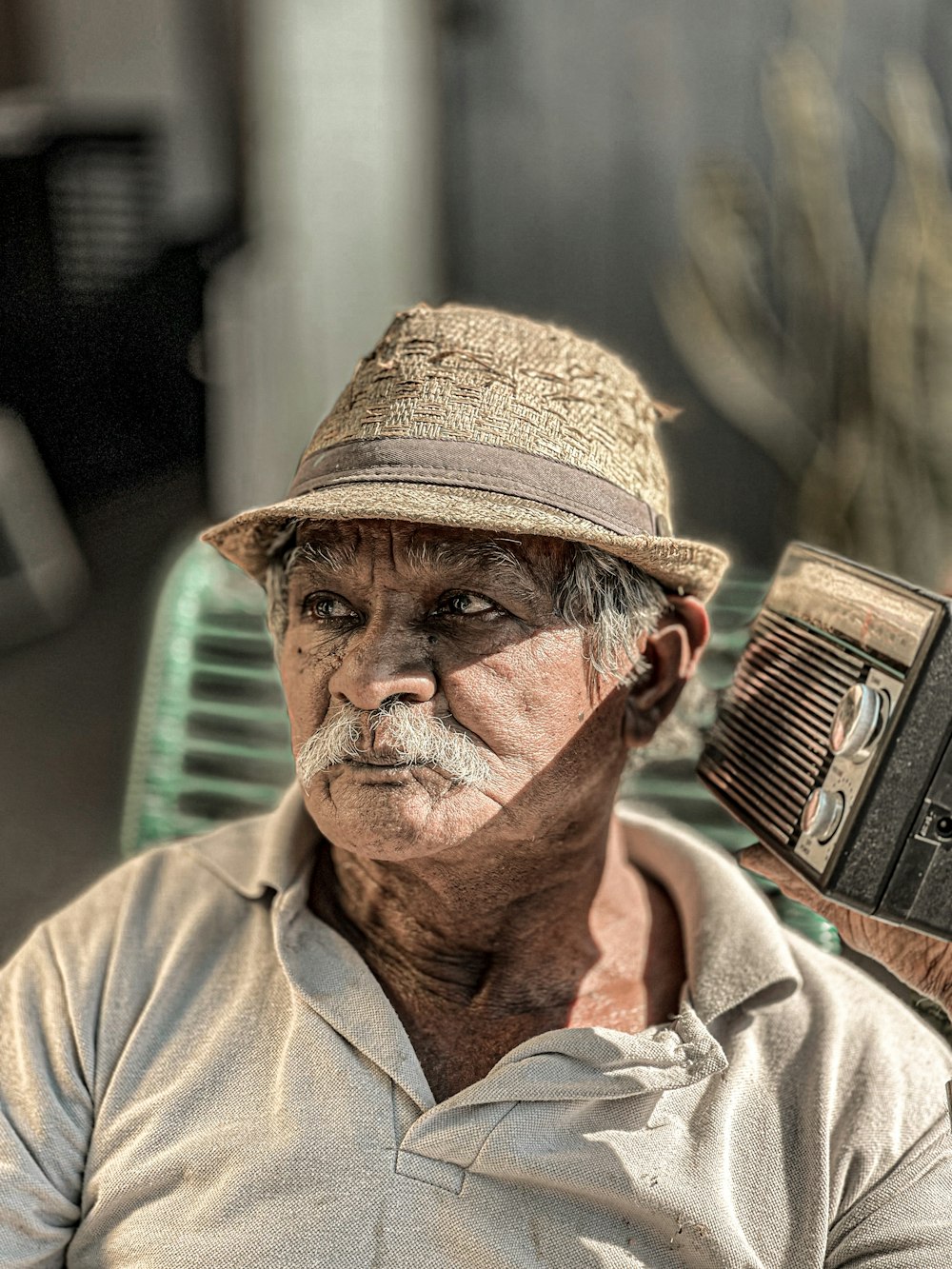 Un hombre con un sombrero y una radio en la mano