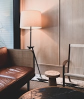 a living room with a couch, chair and lamp