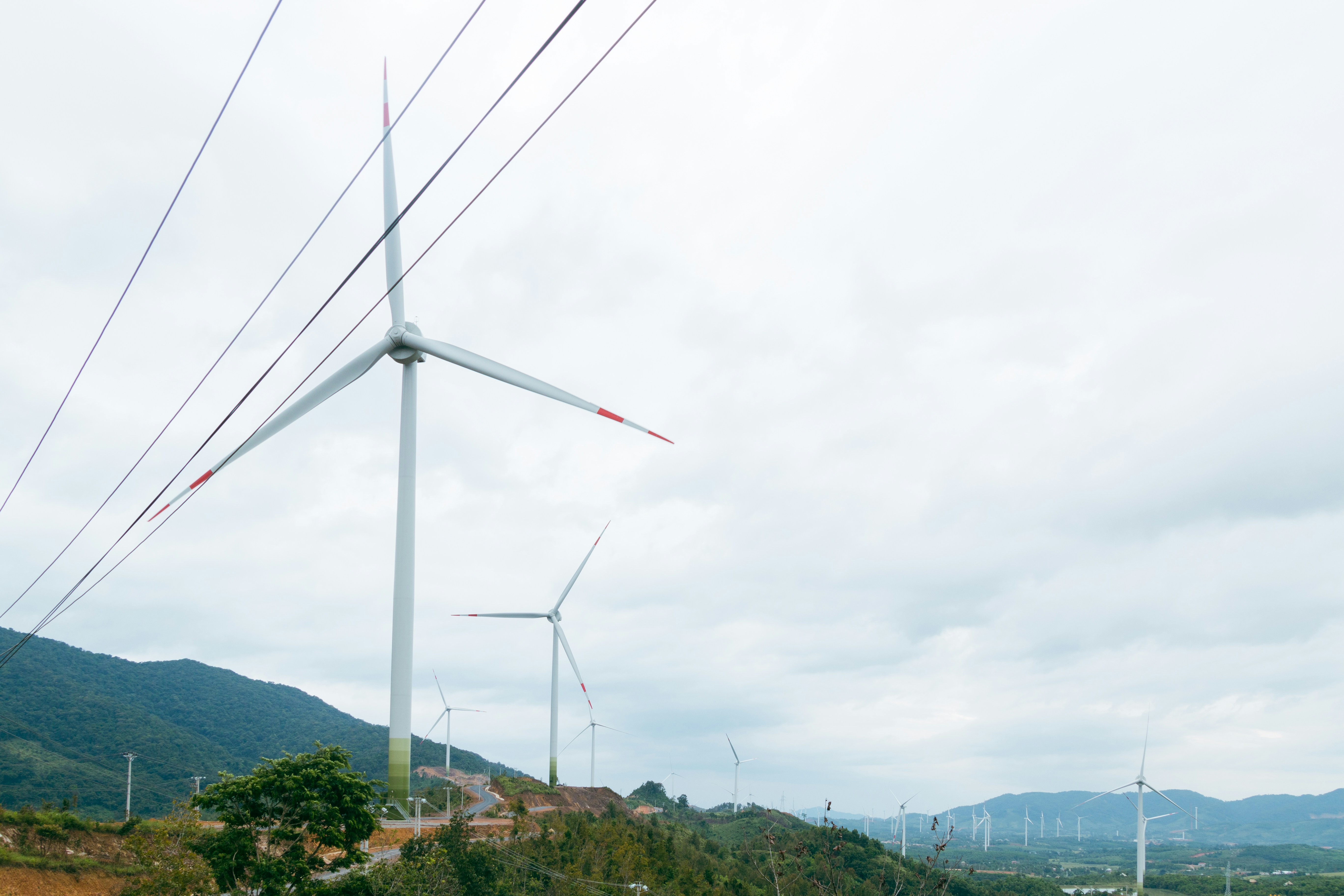 A group of wind turbines on a hill photo – Free Blue Image on Unsplash