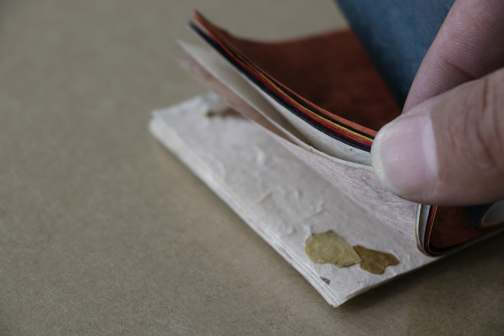 a person holding a piece of paper with a leaf on it