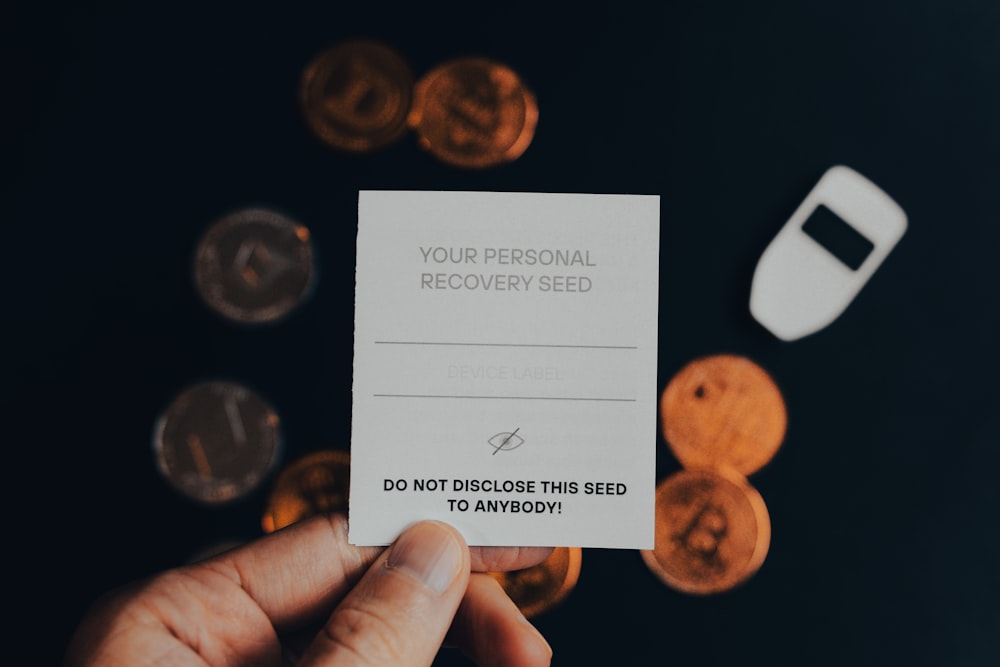 a person holding a business card in front of a pile of coins