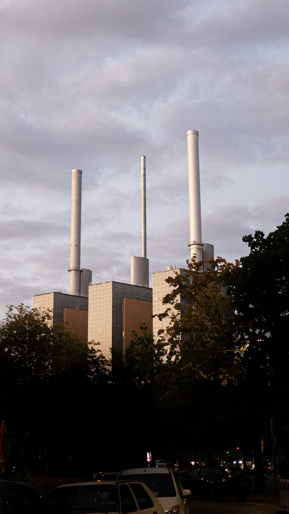 a car parked in front of a factory with smoke stacks