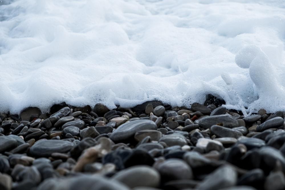 a close up of rocks and water on a beach