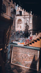 A bustling craft fair booth displaying delicate miniature art pieces under soft lighting.