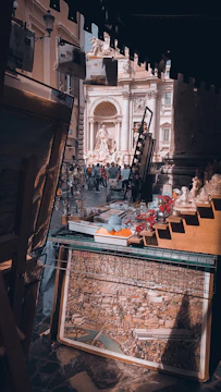 A bustling craft fair booth displaying delicate miniature art pieces under soft lighting.