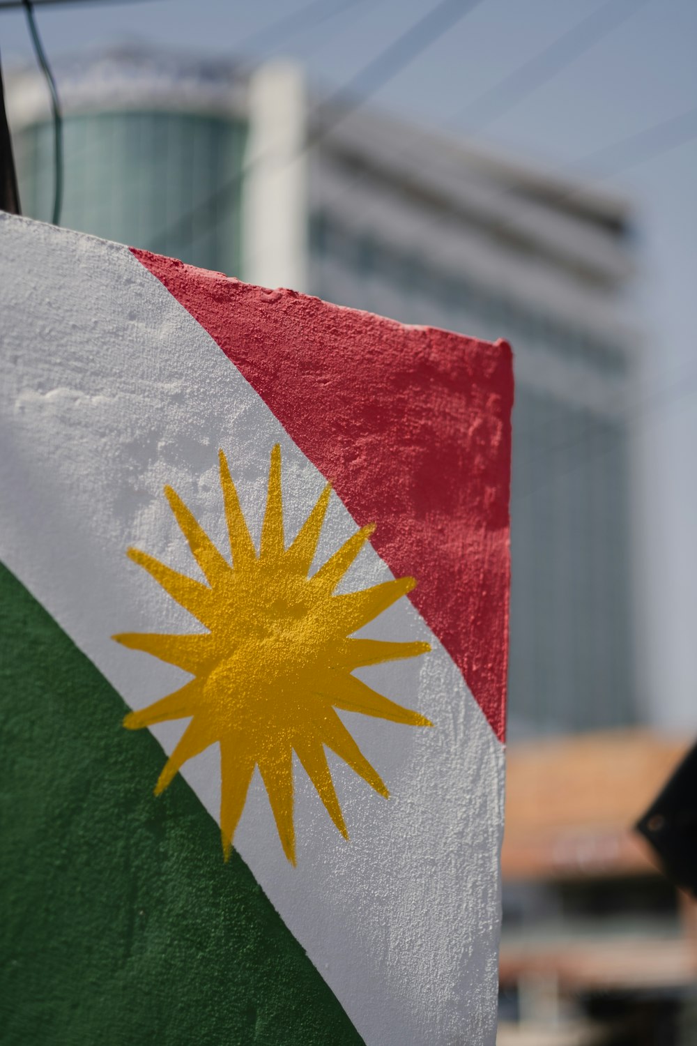 a close up of a flag with a building in the background