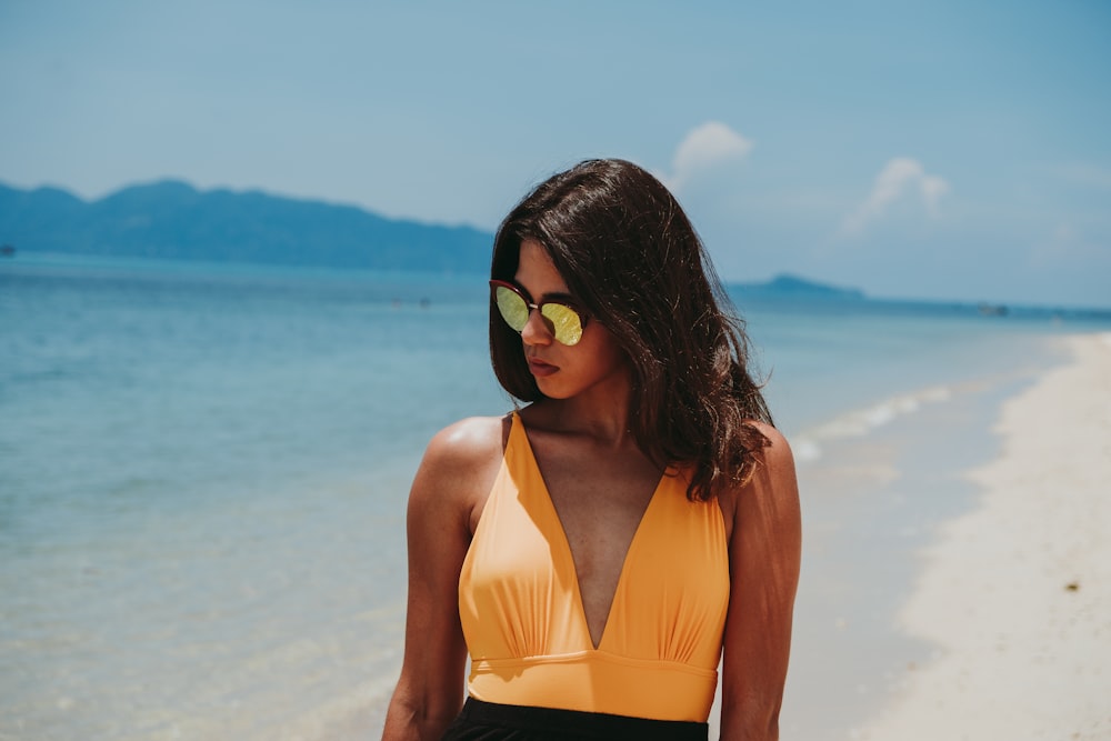 a woman in a yellow bikini on a beach