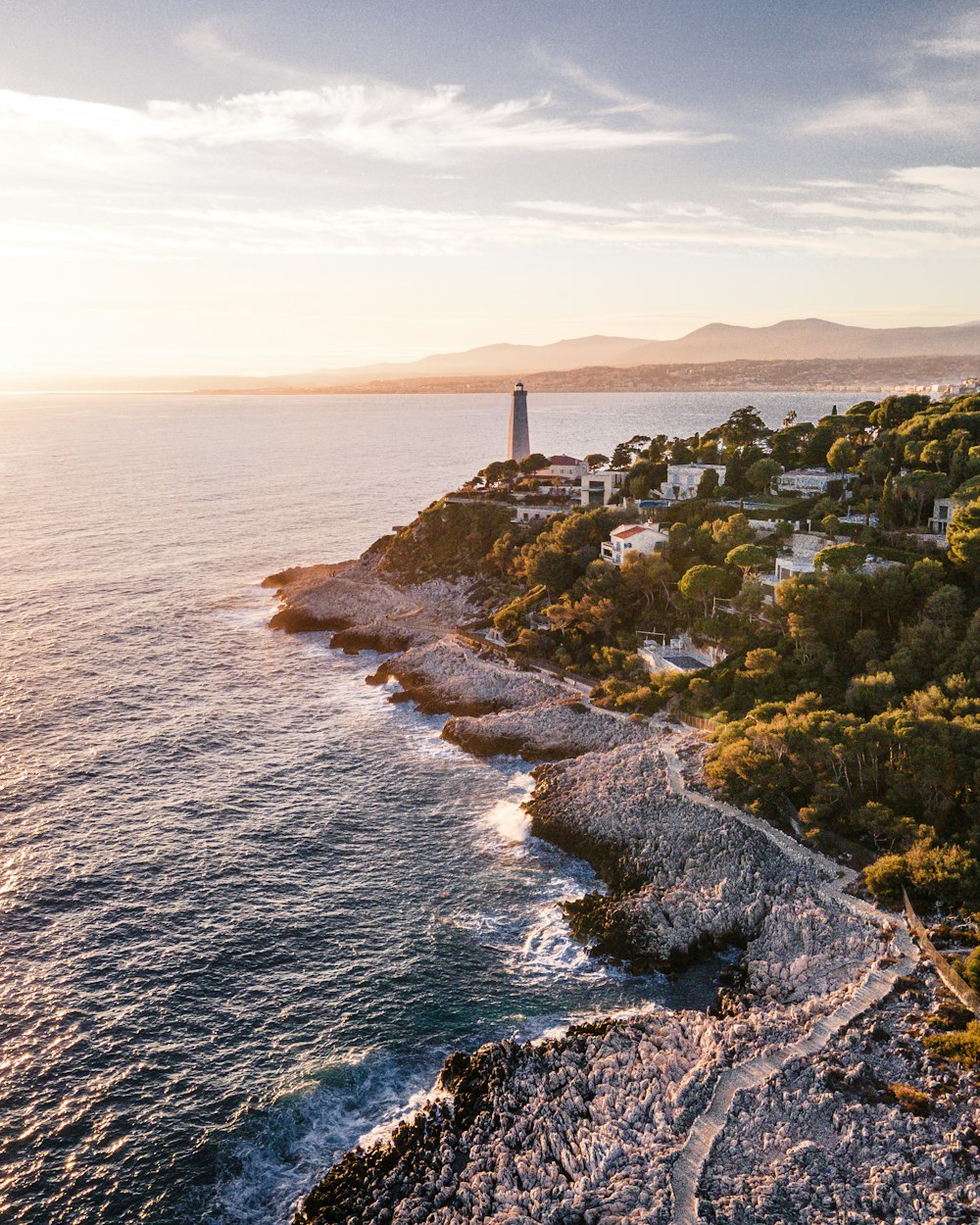 an aerial view of a lighthouse on the coast