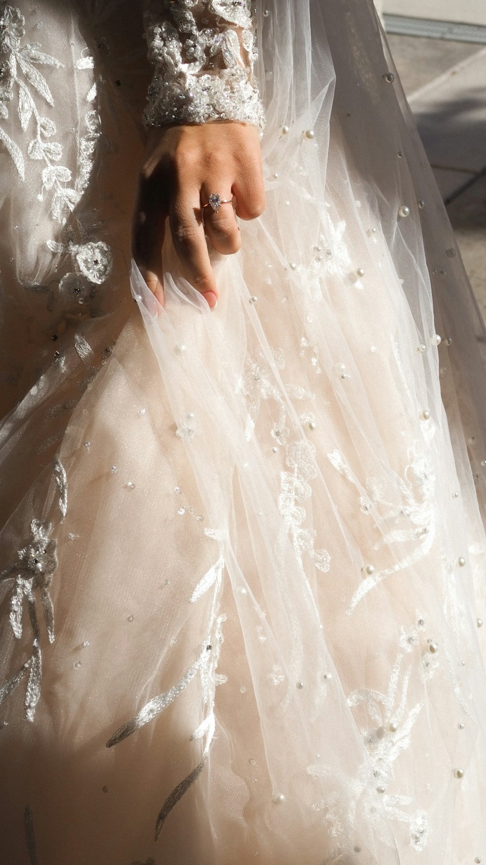 a woman in a wedding dress with a ring on her finger