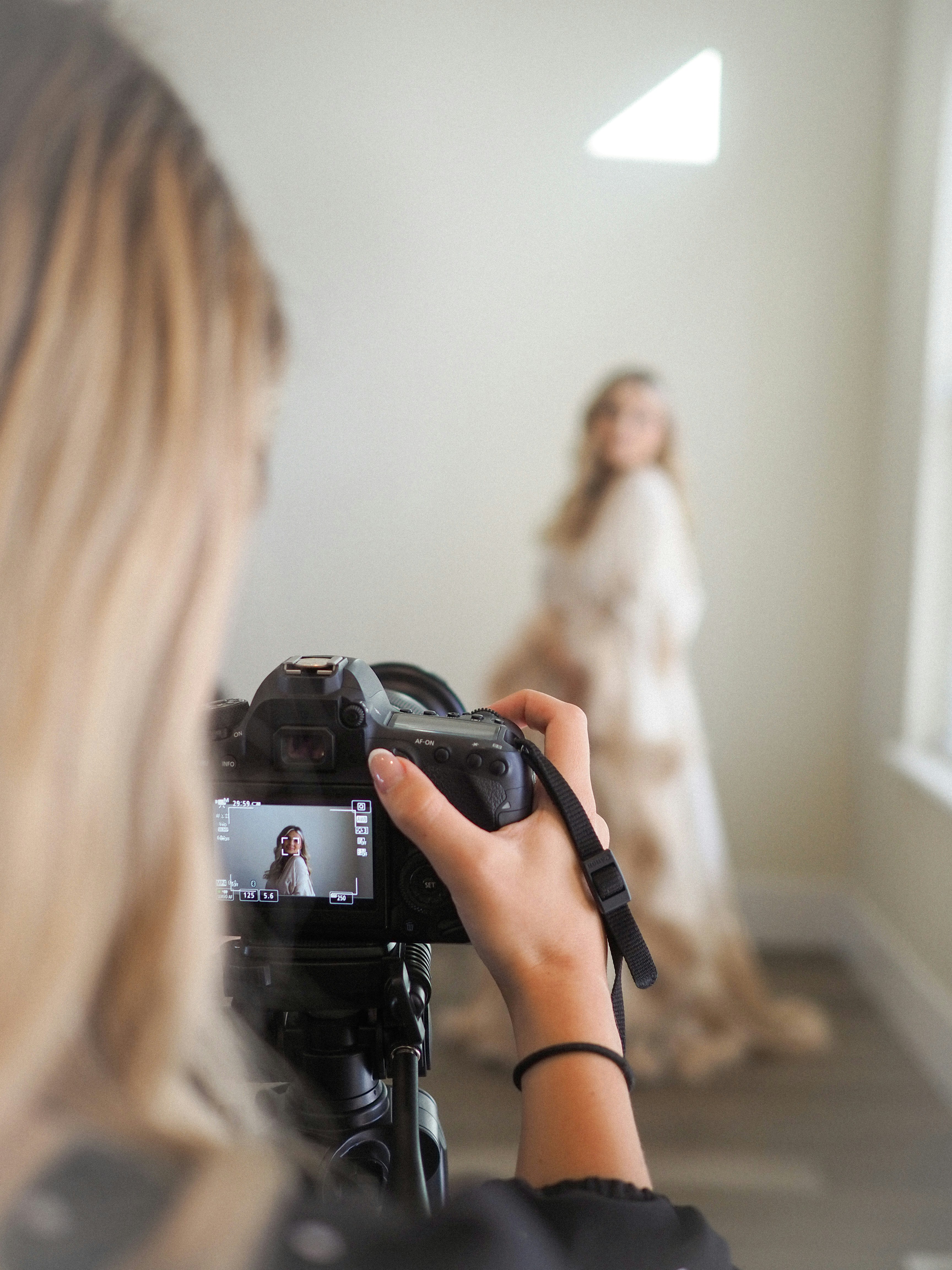 a woman taking a picture of a woman in a wedding dress