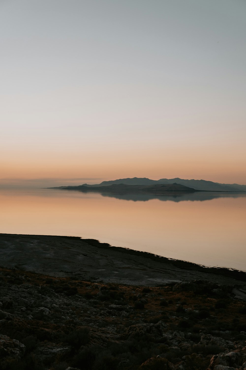 a man standing on top of a hill next to a body of water