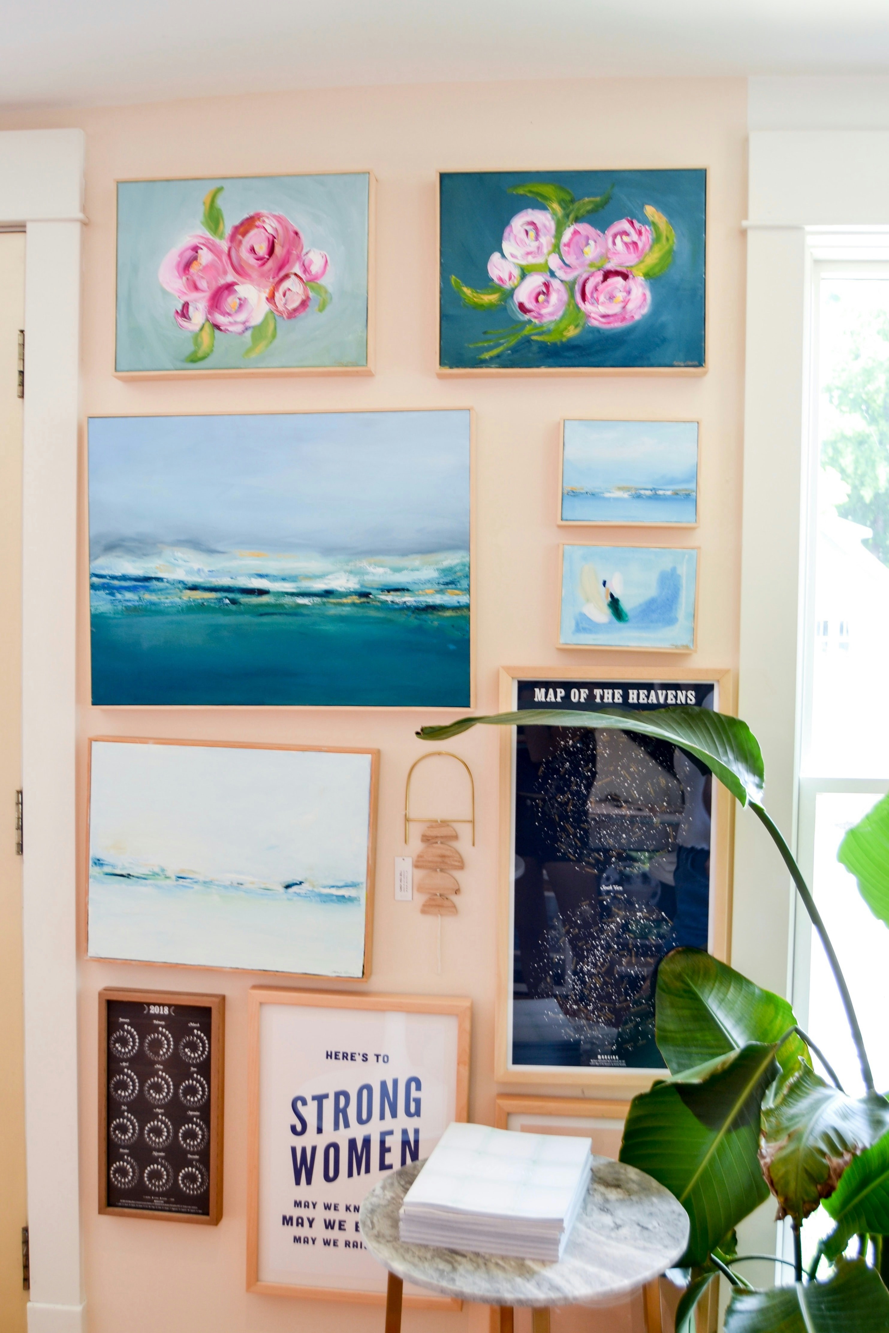 a living room with a bunch of paintings on the wall
