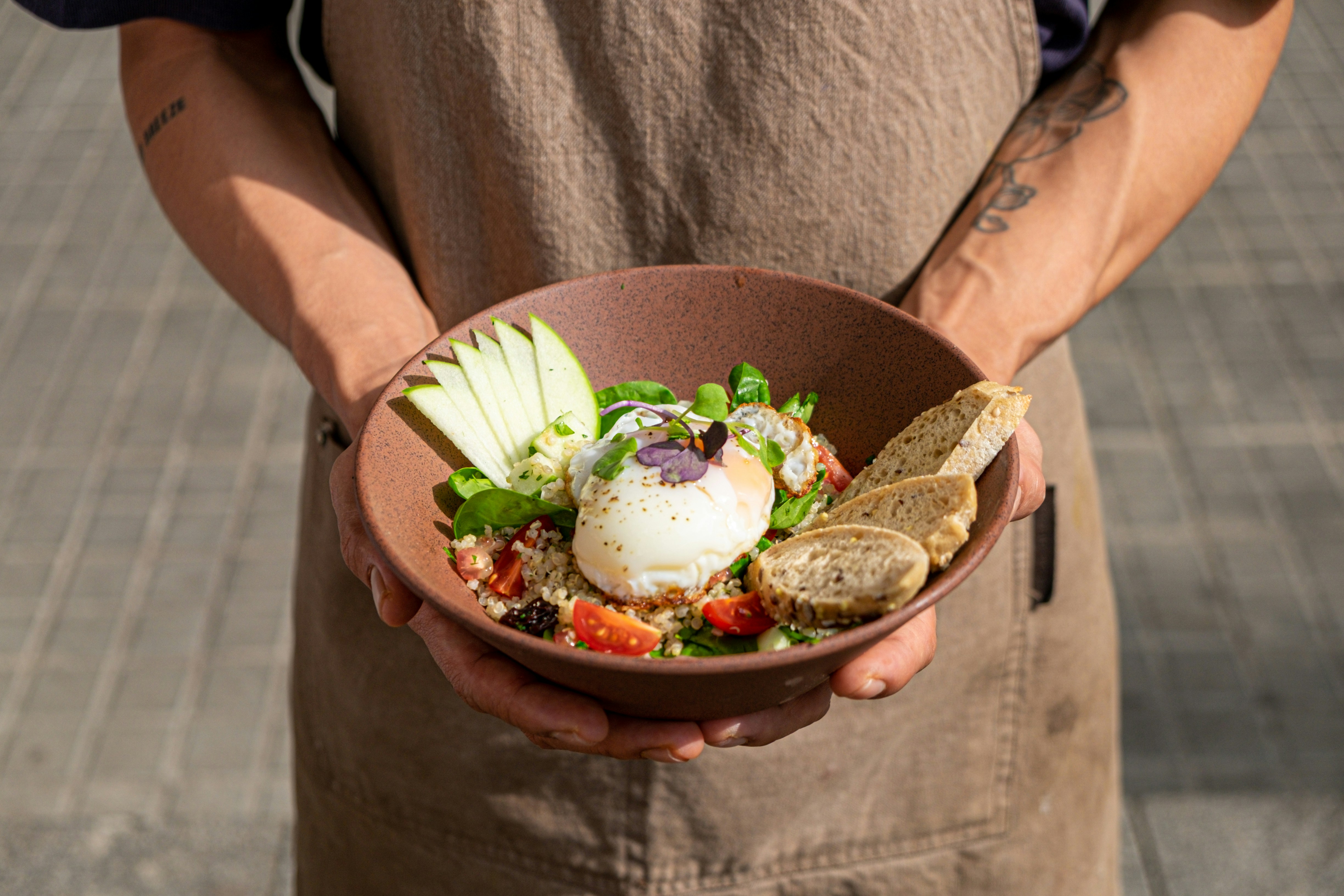 a man is holding a bowl of food