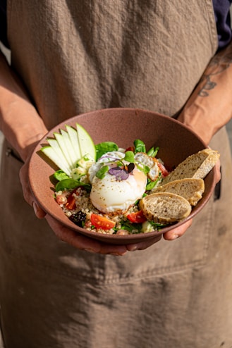 a person holding a bowl of food in their hands