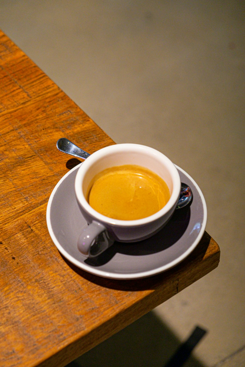 a cup of coffee on a saucer on a wooden table