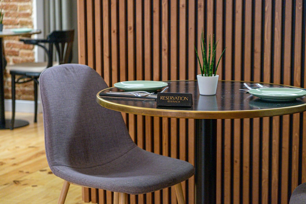 une table avec deux chaises et une plante en pot
