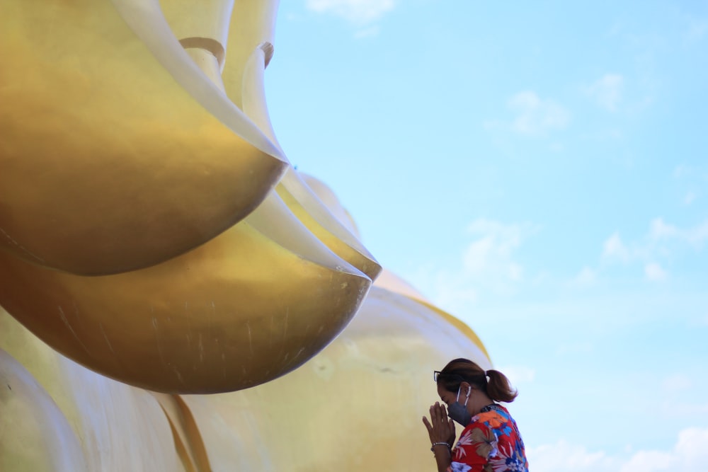 a woman standing next to a giant yellow object