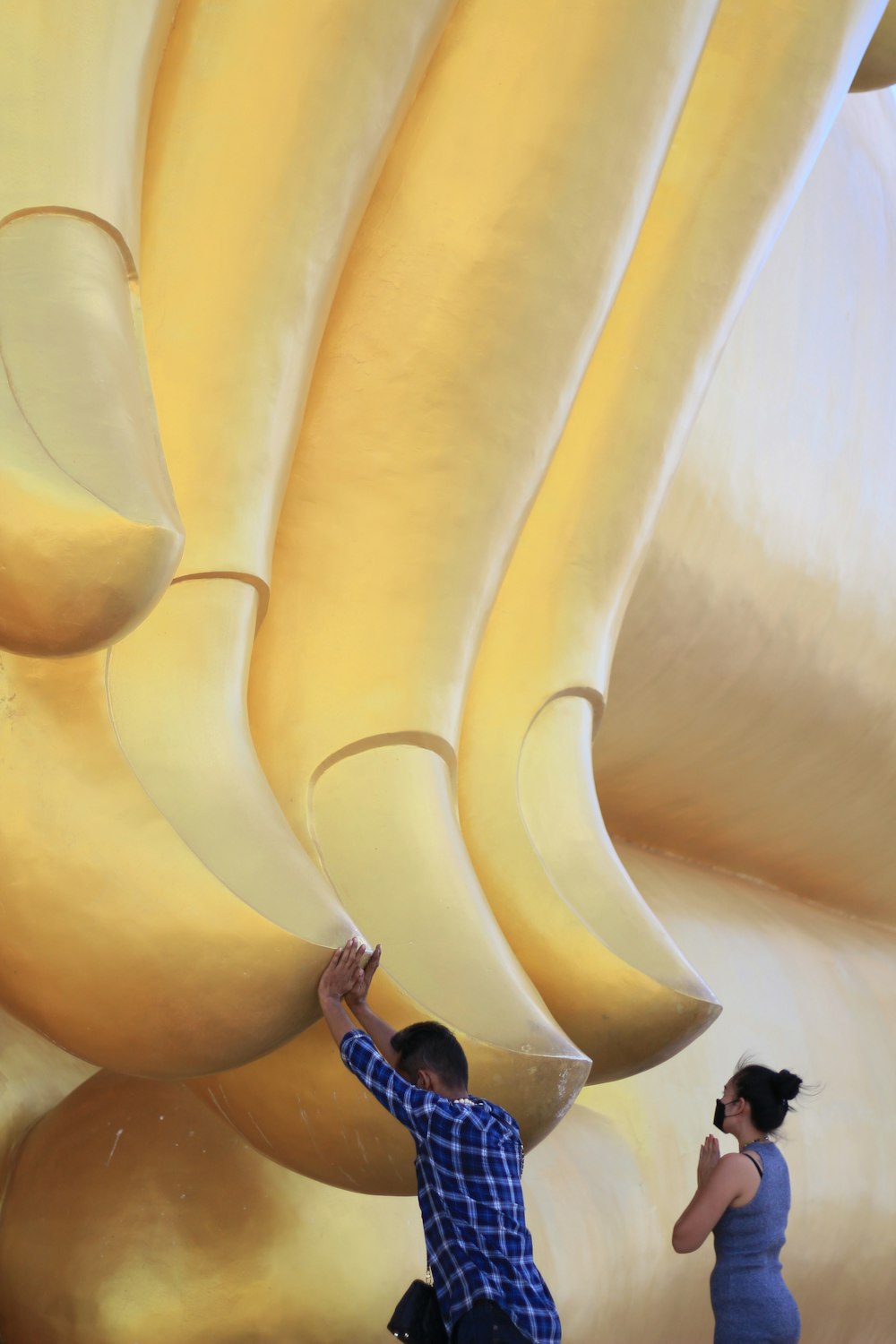 a man and a woman are painting a large banana sculpture