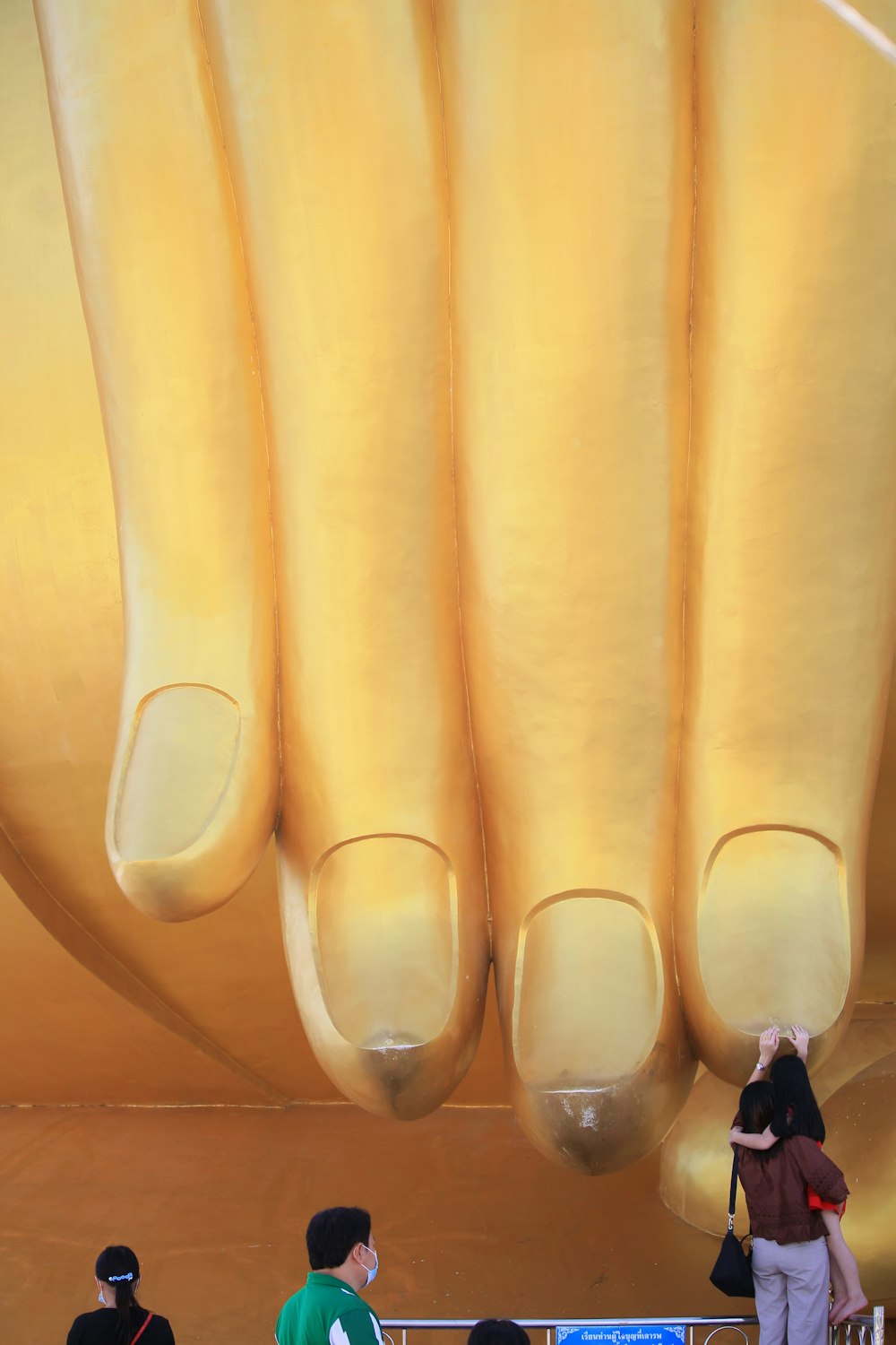 a group of people standing in front of a giant hand