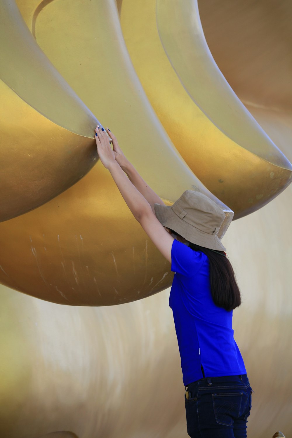 a woman in a blue shirt and a tan hat