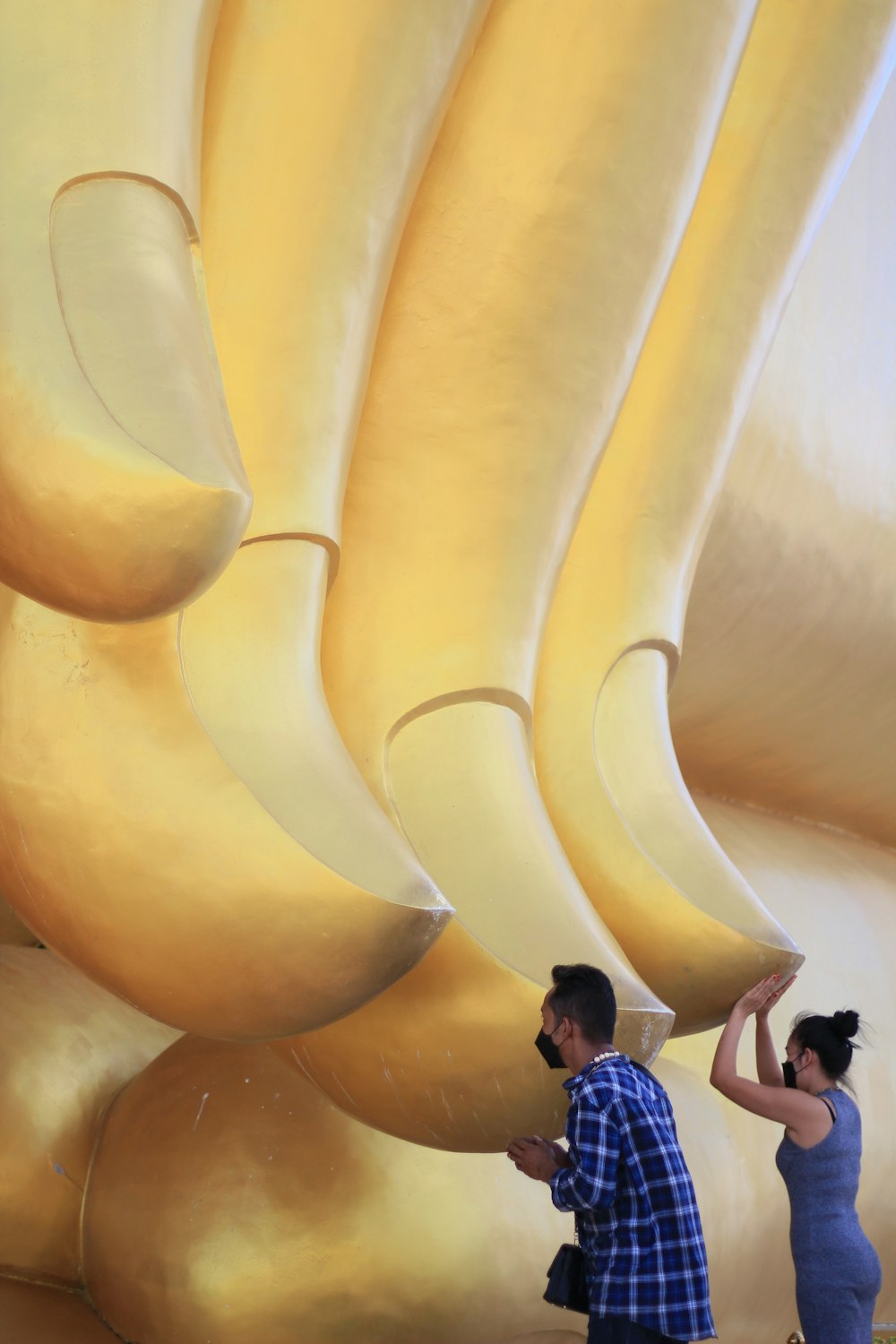 a man and a woman standing in front of a giant banana sculpture