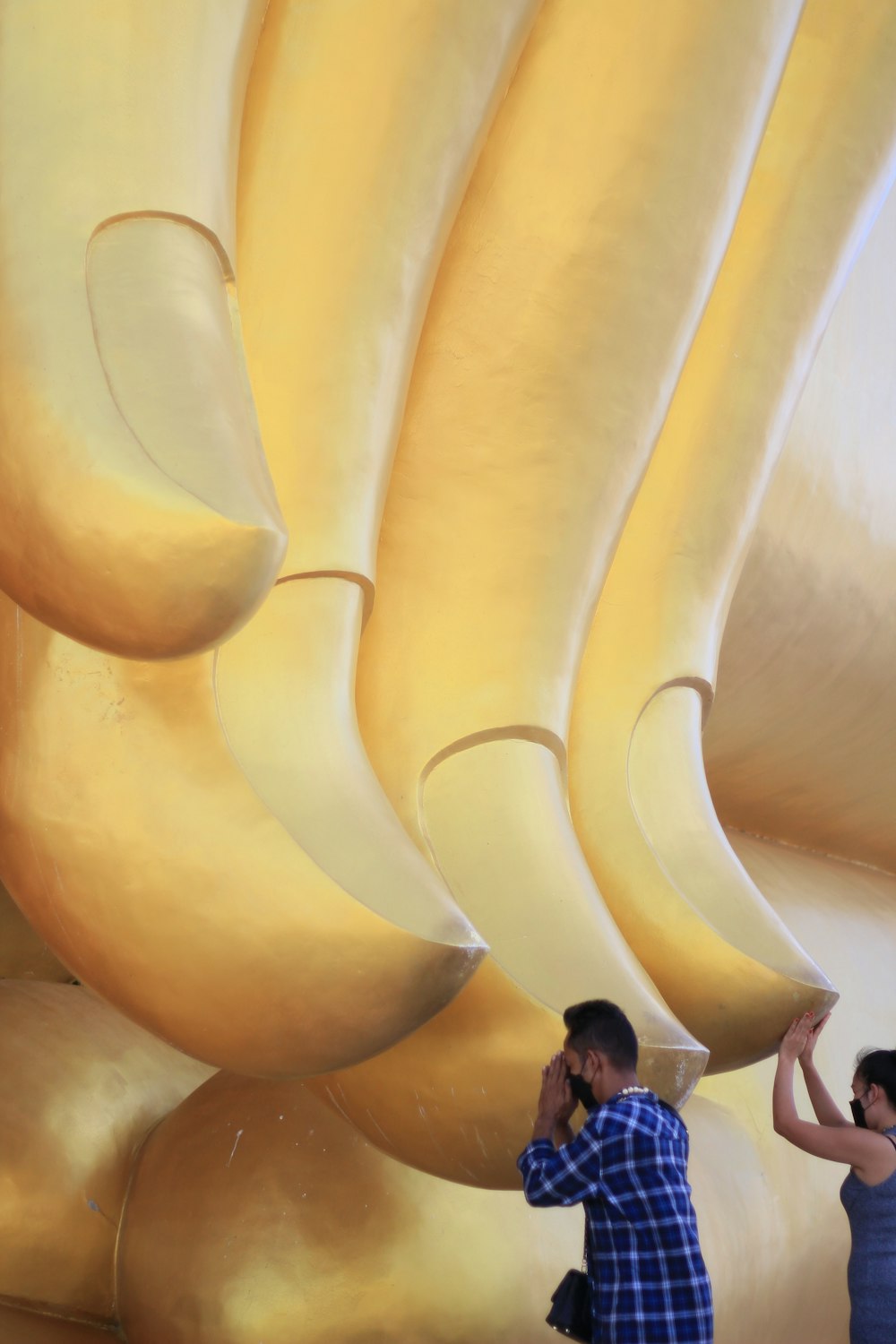 a man and a woman standing in front of a giant banana sculpture