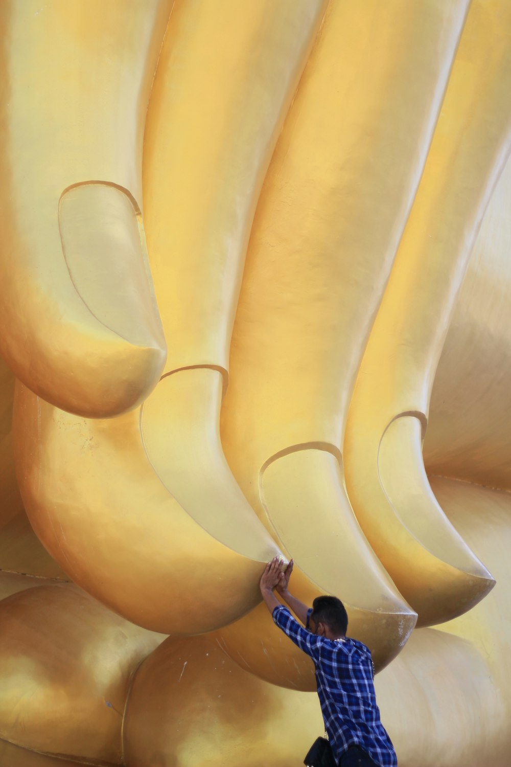 a man standing next to a giant banana sculpture