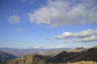 A wide mountain vista under a soft blue sky, evoking spaciousness and stillness.