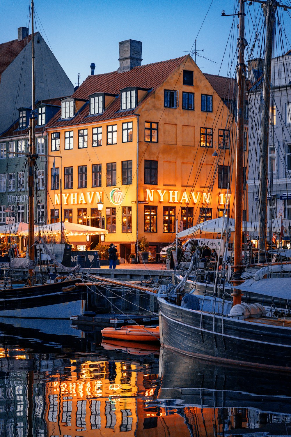 a harbor filled with lots of boats next to tall buildings