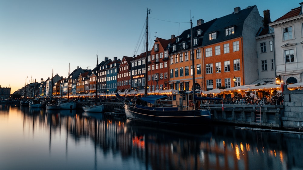 a harbor filled with lots of boats next to tall buildings